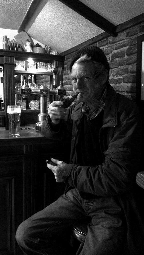 Gary sitting at the bar with a pint and pipe inside The Hidden Naggin