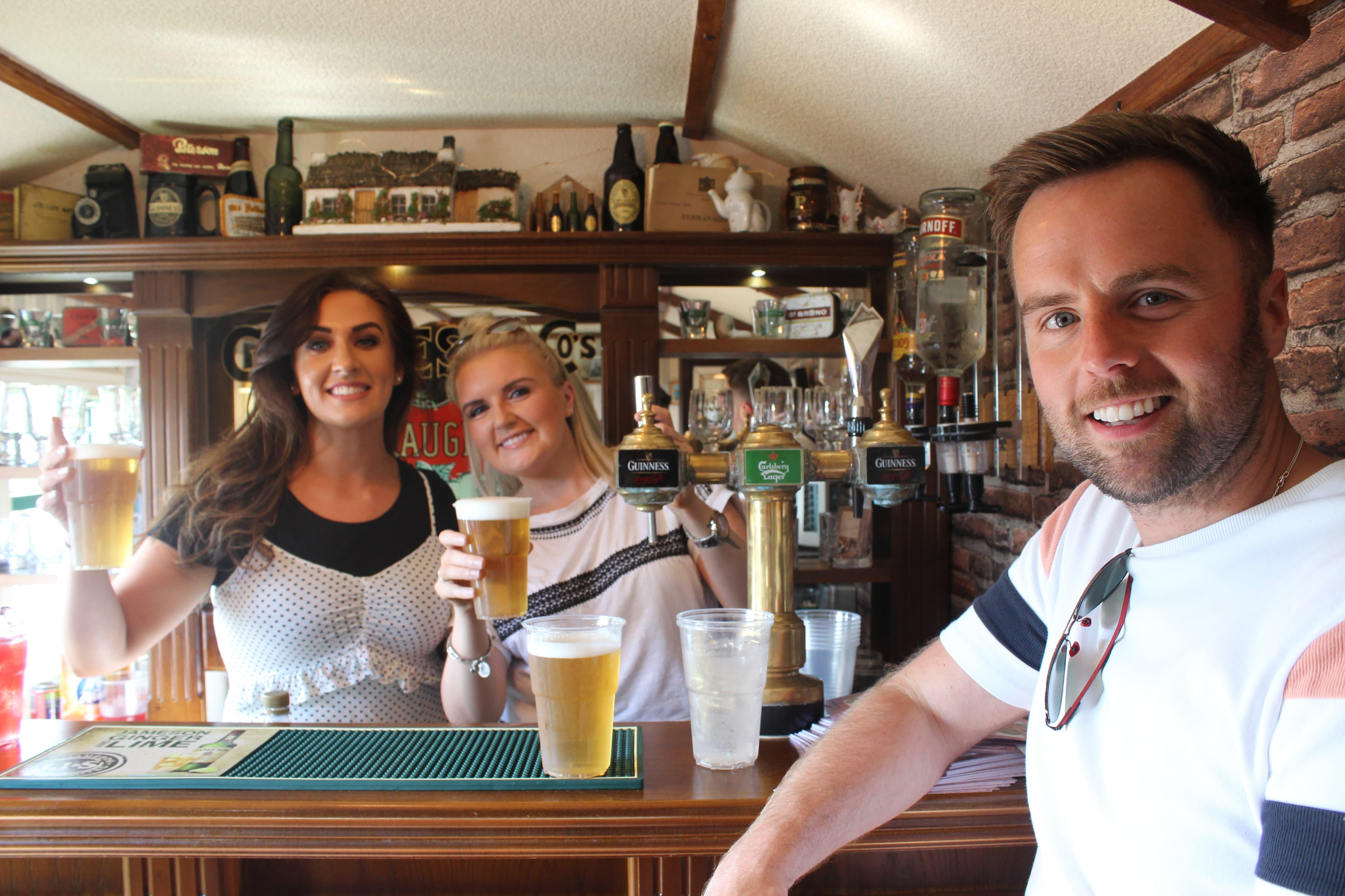 Smiling guests enjoying drinks at the bar