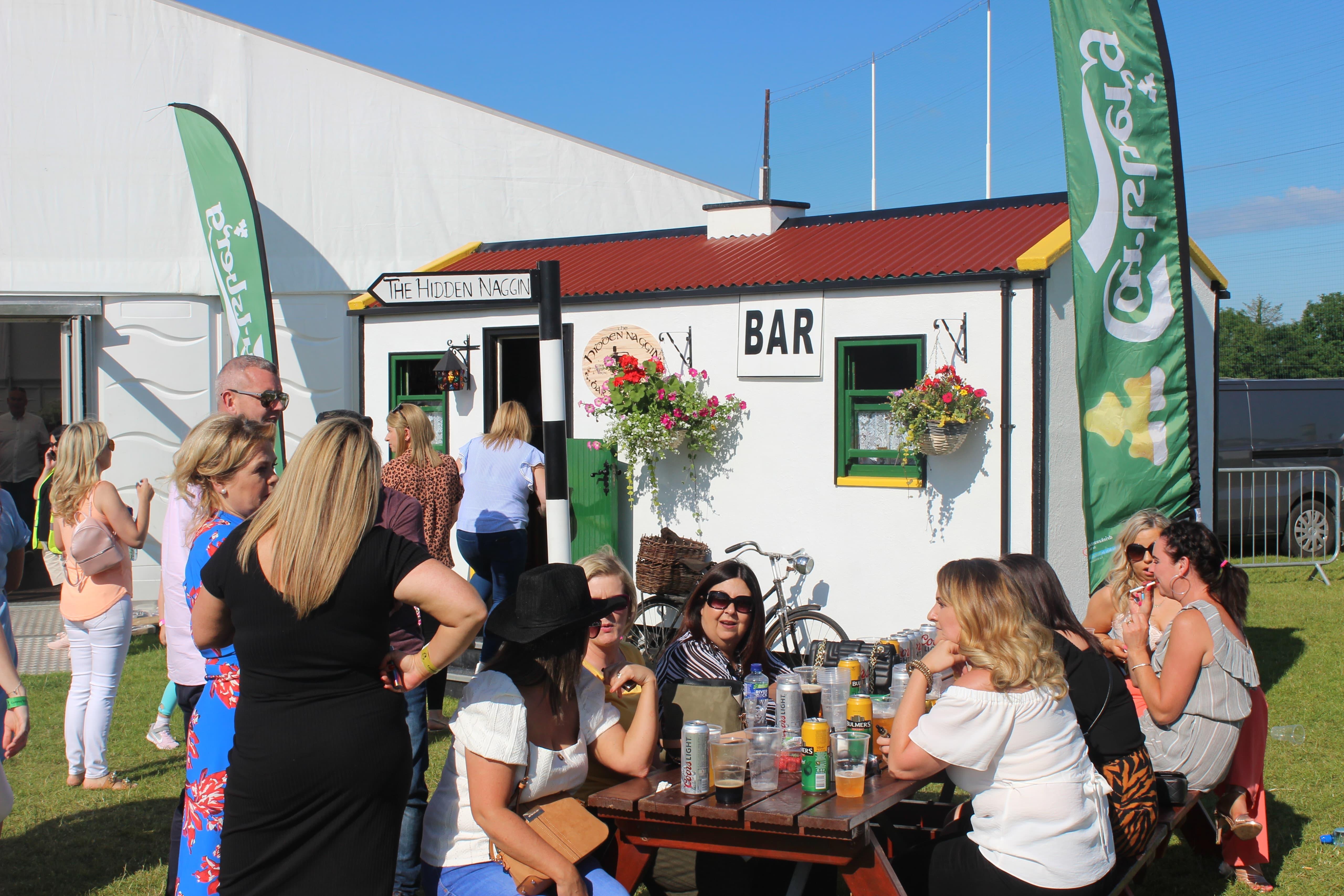 Festival crowd outside The Hidden Naggin with bar sign