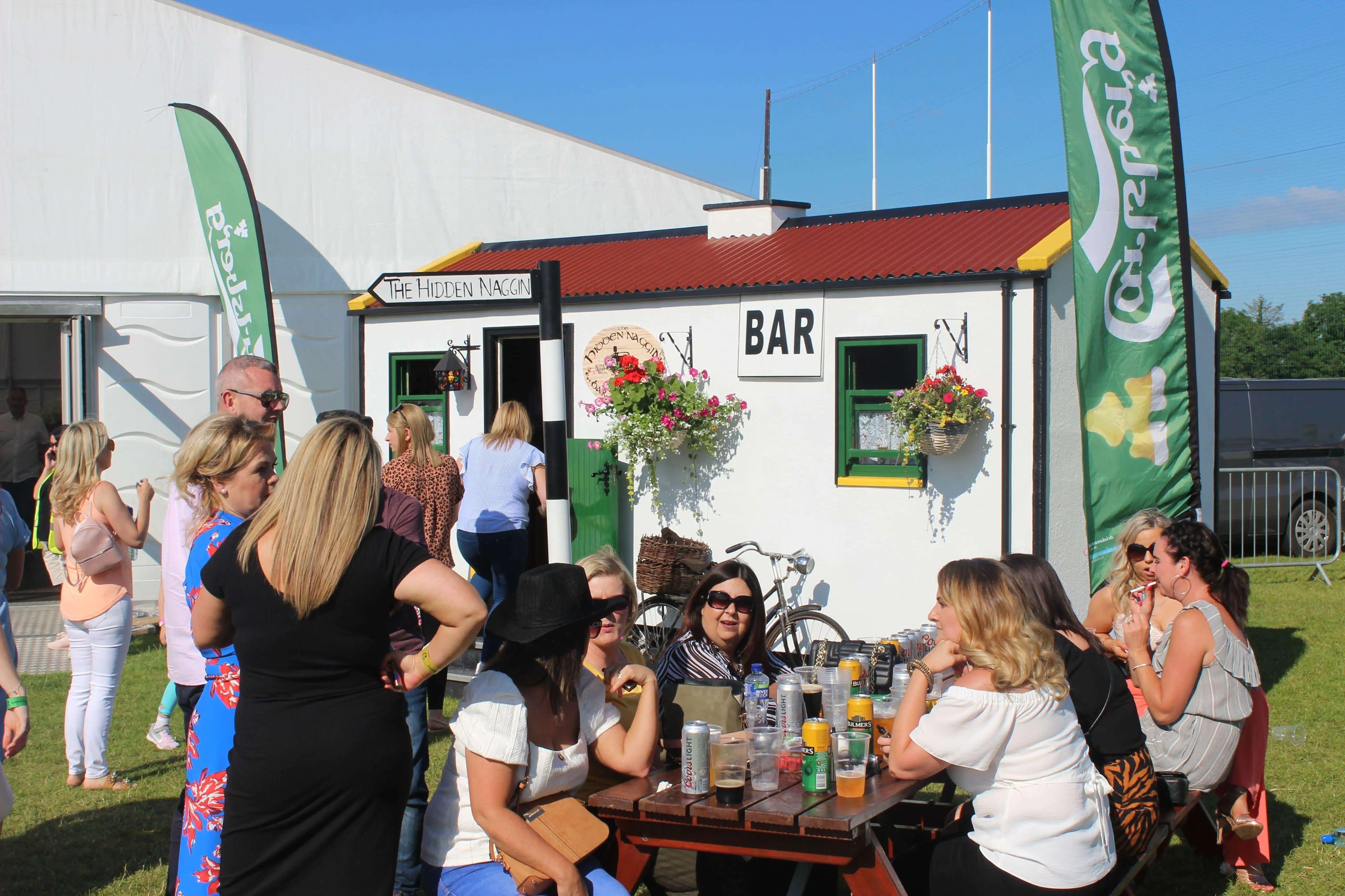 Festival crowd outside The Hidden Naggin with bar sign