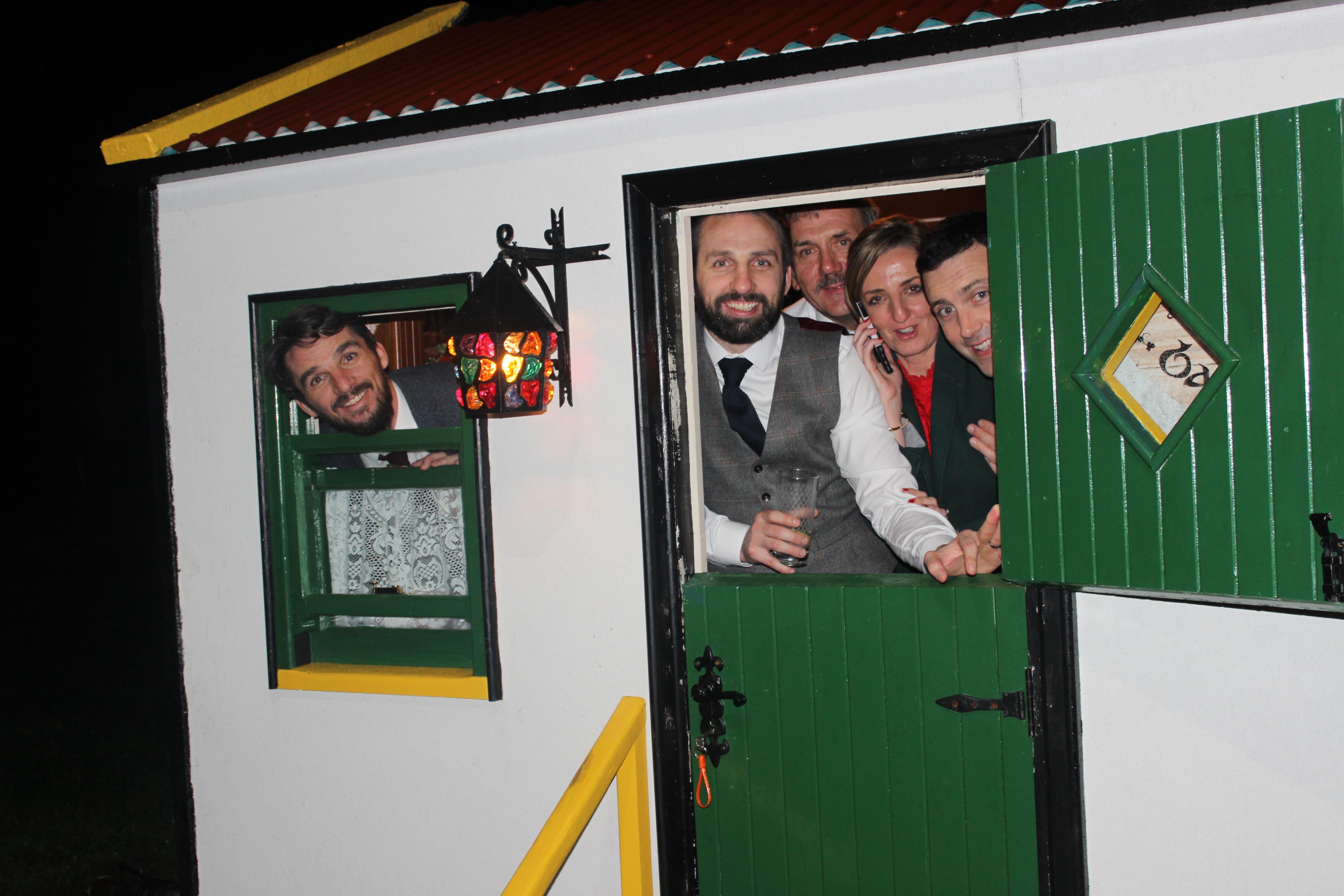 Guests at the doorway of The Hidden Naggin at night