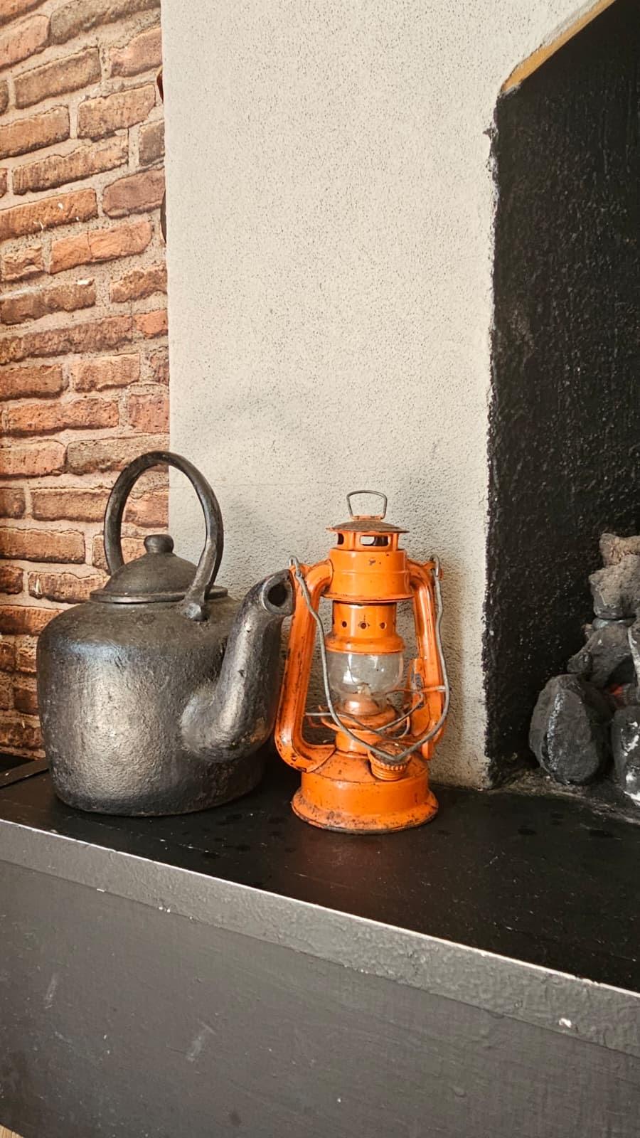 Vintage kettle and lantern beside the fireplace