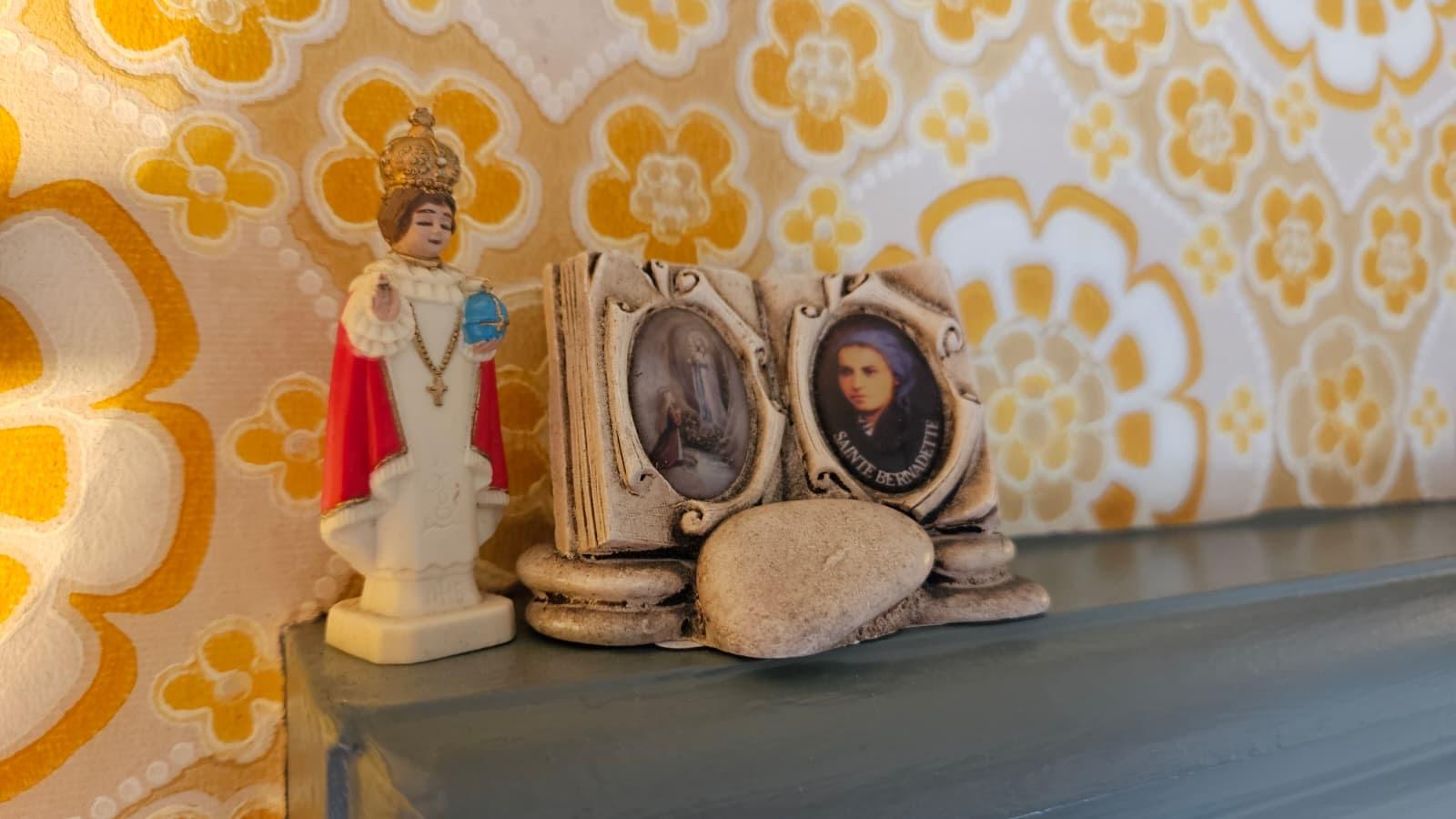Religious keepsakes and vintage wallpaper detail inside